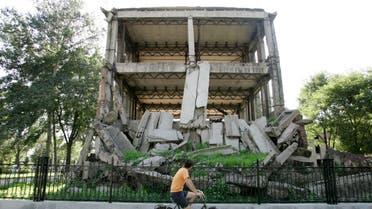 Visitor cycles past ruins of Hebei Polytechnic University library, which was destroyed by the 1976 earthquake, in Tangshan. (Reuters)