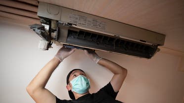 Furloughed aircraft engineer Chutipong Sodvilai cleans air conditioning units to supplement his income in Bangkok. (AP)