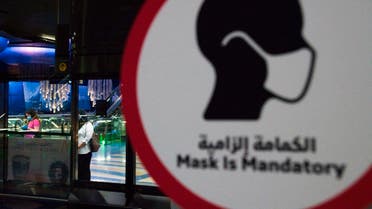 A commuter wearing a mask and disposable gloves due to the coronavirus pandemic waits for the driverless Metro at a station in Dubai. (AP)