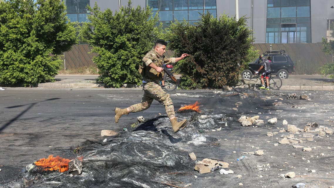 A Lebanese army soldier makes his way through a burnt barricade set on fire by demonstrators during a protest sparked by a rapid fall in the pound currency and mounting economic hardship, along a highway, north of Beirut, Lebanon June 12, 2020. (Reuters)