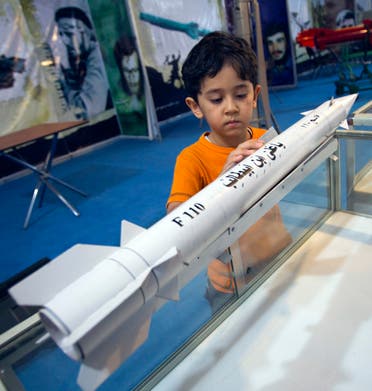 A boy looks at a model of an Iranian third-generation Fateh-110 surface-to-surface missile while visiting a war exhibition in south-eastern Tehran. (Reuters)