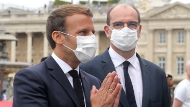 French President Emmanuel Macron (L) wearing a protective facemask greets guests flanked by French Prime Minister Jean Castex at the end of the annual Bastille Day military ceremony on the Place de la Concorde in Paris, on July 14, 2020. (AFP)