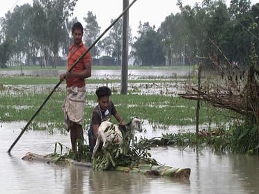 In this video grab  Bangladeshi men with a goat row a banana raft through flood waters in Lalmonirhat, Bangladesh, on July 13, 2020. (AP)