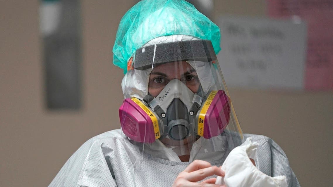 Registered Nurse Candace Trammeor grabs shoe coverings inside the Coronavirus Unit at United Memorial Medical Center, Monday, July 6, 2020, in Houston. (AP)