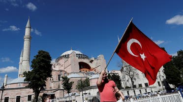A man waves a Turkish Flag in front of the Hagia Sophia or Ayasofya, after a court decision that paves the way for it to be converted from a museum back into a mosque, in Istanbul, Turkey, July 10, 2020. (Reuters)