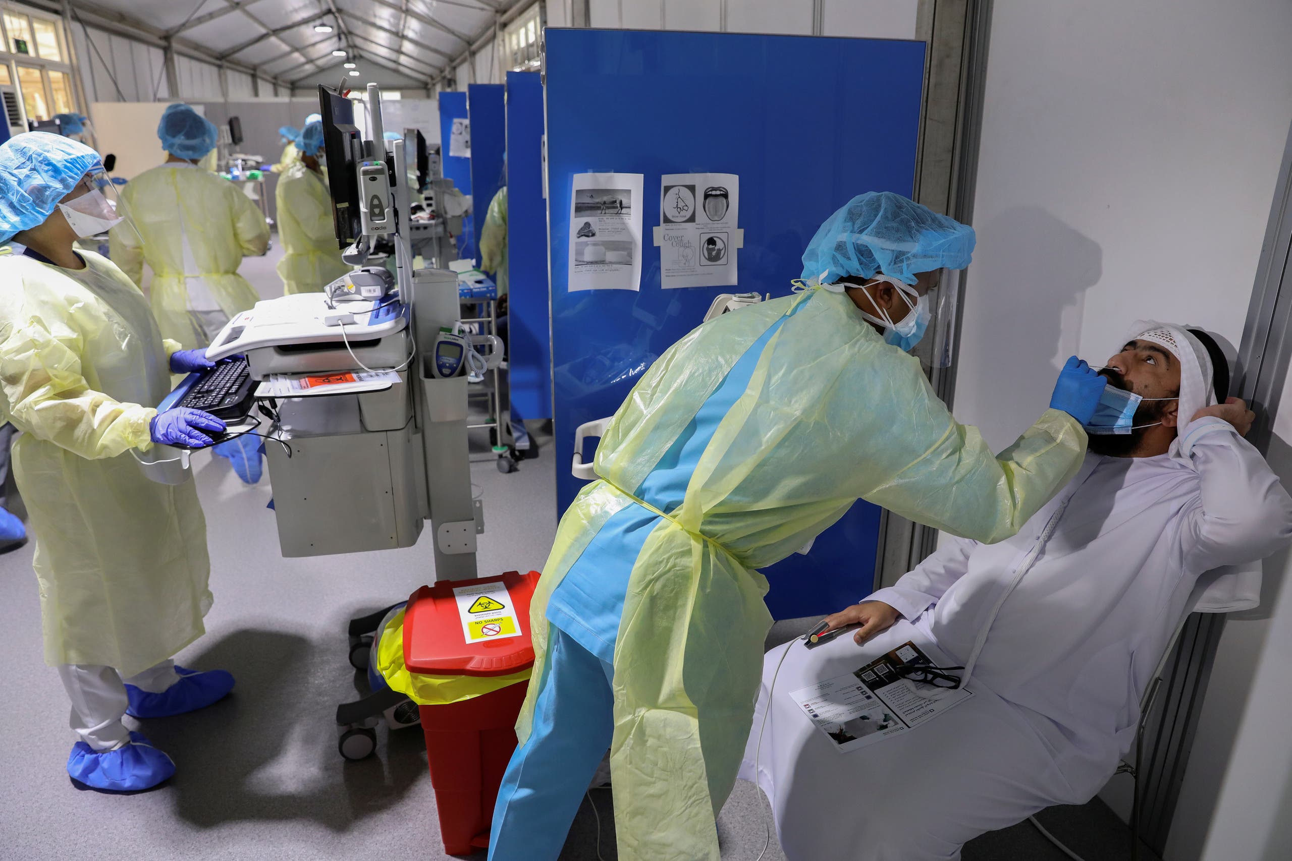 A medical worker wearing protective equipment swabs a man during testing, amid the coronavirus disease (COVID-19) outbreak, at the Cleveland Clinic hospital in Abu Dhabi, United Arab Emirates, April 20, 2020. (Reuters)