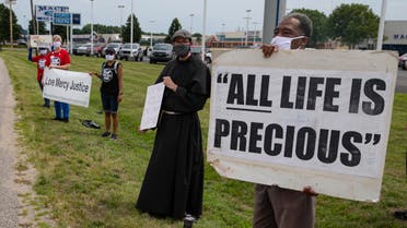 A protester holds a sign demonstrating against the death penalty in the US. (AP)