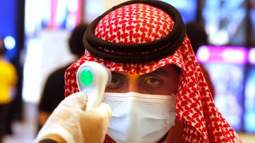 A Saudi cinema viewer has his temperature taken as he wears a face mask to help curb the spread of the coronavirus, at VOX Cinema hall in Jiddah, Saudi Arabia, Friday, June 26, 2020, after the announcement of easing of lockdown measures amid the coronavirus outbreak. (AP Photo/Amr Nabil)