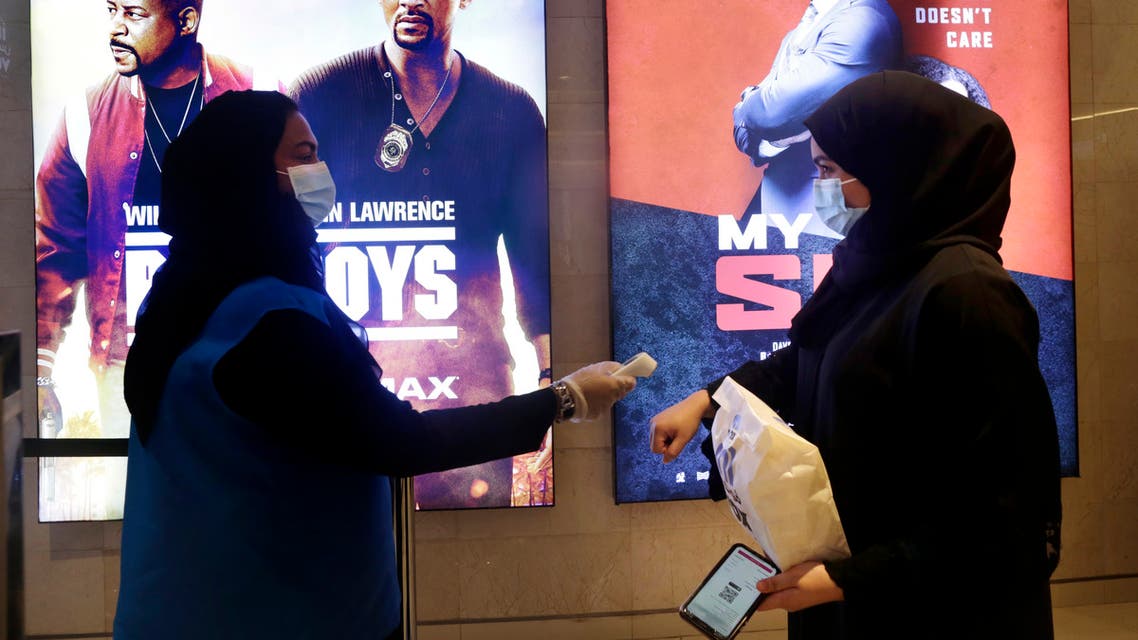 A Saudi movie viewer has her temperature taken as she wears a face mask to help curb the spread of the coronavirus, at VOX Cinema hall in Jiddah, Saudi Arabia, Friday, June 26, 2020, after the announcement of easing of lockdown measures amid the coronavirus outbreak. (AP Photo/Amr Nabil)