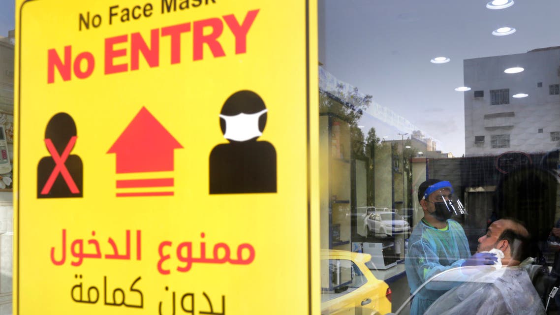 A poster showing healthy procedures to help curb the spread of the coronavirus, hangs at a barber shop window in Jiddah, Saudi Arabia, Sunday, June 28, 2020. (AP Photo/Amr Nabil)