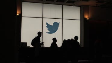 Employees walk past a lighted Twitter log as they leave the company’s headquarters in San Francisco on August 13, 2019. (AFP)