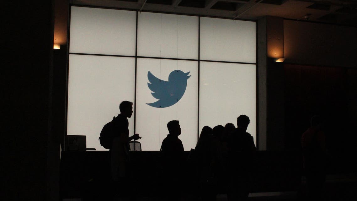 Employees walk past a lighted Twitter log as they leave the company’s headquarters in San Francisco on August 13, 2019. (AFP)
