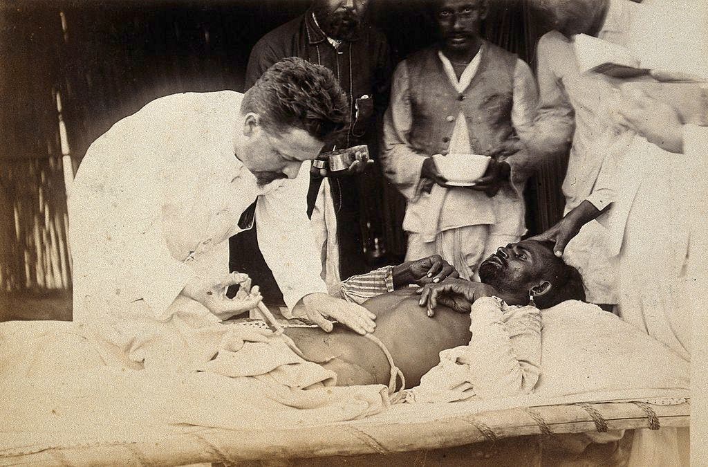 صورة لعملية علاج أحد المصابين بالطاعون بكراتشي عام 1897