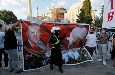 People hold a placard showing Turkish President Tayyip Erdogan and Ottoman sultan Mehmed II in front of the Hagia Sophia or Ayasofya in Istanbul. (Reuters)