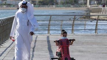 A Saudi man and his daughter stroll down the seafront promenade in the Saudi seaport of jeddah, on June 21, 2020, as the country re-opens following the lifting of a lockdown due to the COVID-19 pandemic. 