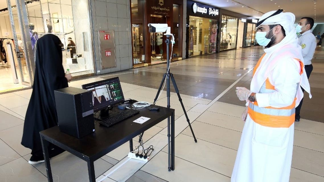 Kuwaiti security check a visitor's temperature at the entrance of a mall on June 30, 2020 in Kuwait City. (AFP)