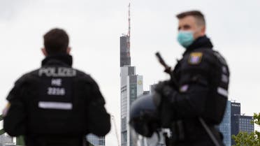 n this file photo taken on May 23, 2020 police officers wearing face masks are pictured in during a rally against restrictions in place to limit the spread of the new coronavirus COVID-19 pandemic in Frankfurt. (AFP)