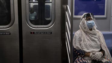 A woman wearing a face mask and shield sits in a subway train during rush hour amid the coronavirus pandemic on July 16, 2020, in New York City. (AFP)