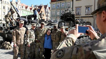 A file photo shows a woman takes a picture with U.S. soldiers, who are part of a NATO multinational battalion battlegroup on their way from Germany to Orzysz, northeastern Poland. (Reuters)