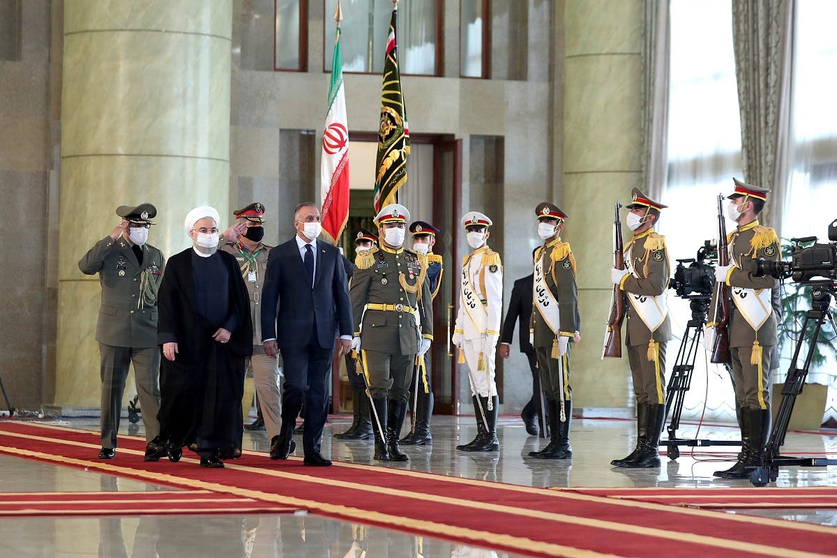 Iranian President Rouhani and Iraqi PM al-Kadhimi walk during a welcome ceremony, as they wear protective masks, in Tehran, Iran, July 21 2020. (Reuters)