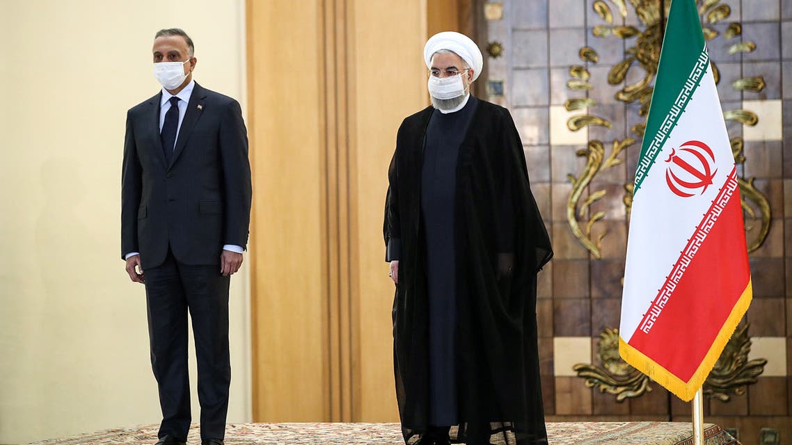 A handout picture provided by the Iranian presidency on July 21, 2020, shows the mask-clad (COVID-19 coronavirus pandemic precaution) President Hassan Rouhani (R) receiving Iraq's Prime Minister Mustafa al-Kadhemi (L) in the capital Tehran.