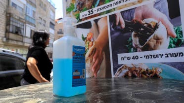 A bottle of sanitizing gel stands at the entrance of restaurant in Jerusalem on May 27, 2020. (AFP)