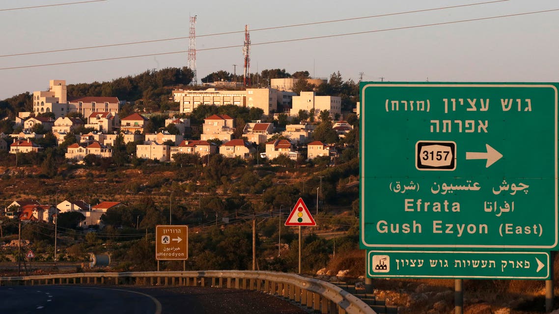 om tThe Israeli settlement of Efrata on the southern outskirts of Bethlehem, behind a road sign towards the right locating the settlement block of Gush Etzion, in the occupied West Bank, on June 27, 2020. (AFP)
