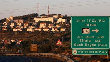 om tThe Israeli settlement of Efrata on the southern outskirts of Bethlehem, behind a road sign towards the right locating the settlement block of Gush Etzion, in the occupied West Bank, on June 27, 2020. (AFP)