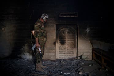 A Nineveh Plain Protection Units, or NPU, fighter inspects the interior of a church damaged by Islamic State fighters during their occupation of Qaraqosh, east of Mosul. (File photo: AP)