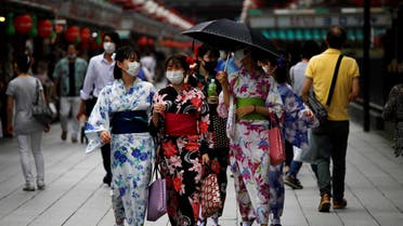 Women in yukata, or casual summer kimonos, wearing protective face masks, walk at Asakusa district amid the coronavirus disease (COVID-19) outbreak in Tokyo. (Reuters)