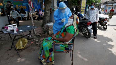 FILE PHOTO: A healthcare worker wearing a protective gear takes a swab from a woman for a rapid antigen test, amidst the coronavirus disease (COVID-19) outbreak, at a roadside testing centre in Ahmedabad, India, July 20, 2020. REUTERS/Amit Dave/File Photo