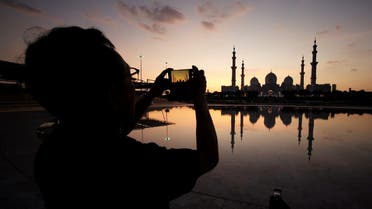 A visitor takes photos of Sheikh Zayed Mosque with their smart phone in Abu Dhabi. (Reuters)