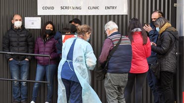 A medical worker (centre L) speaks to people queueing outside a COVID-19 coronavirus testing venue at The Royal Melbourne Hospital in Melbourne on July 16, 2020. Melbourne, which is undergoing a six week lockdown, has recorded 317 new coronavirus cases, the largest biggest daily increase since the pandemic started in Australia.