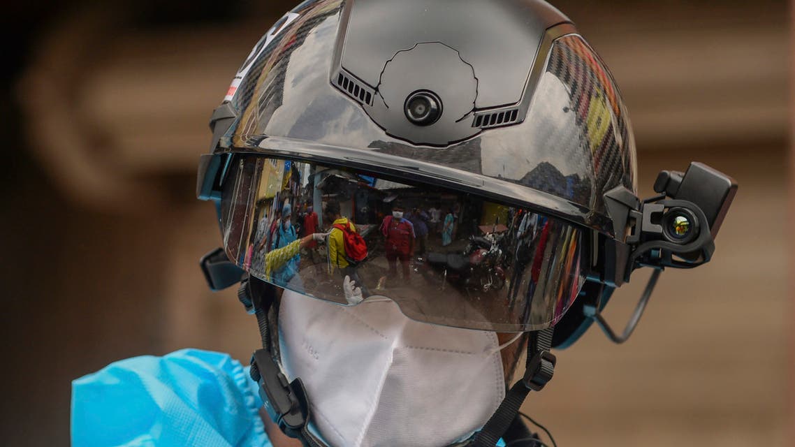 A volunteer health worker of the Non-Governmental Organization (NGO) Bharatiya Jain Sanghatana (BJS) wearing Personal Protective Equipment (PPE) using a smart helmet equipped with a thermo-scan sensor checks the body temperature of residents during a door-to-door medical screening drive for the COVID-19 coronavirus, at a residential area in Mumbai on July 21, 2020. India on July 17 hit a million coronavirus cases, the third-highest total in the world, with no sign yet of the infection curve flattening as new cases emerge in rural areas. More than 25,000 people have died nationally.