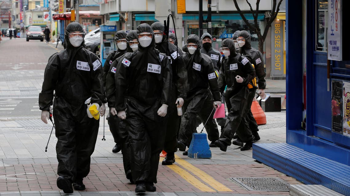 South Korean soldiers in protective gear make their way while they disinfect buildings downtown, following the rise in confirmed cases of coronavirus disease (COVID-19) in Daegu, South Korea, March 15, 2020. REUTERS/Kim Kyung-Hoon