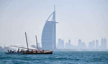 The crew of a competing boat in the annual long-distance 60ft Dubai Traditional Dhow Sailing Race, work on the sail across from Burj Al Arab. (File photo: AFP)