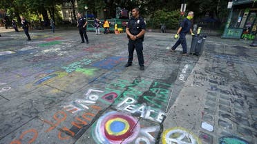 New York police officers standby as sanitation workers remove graffiti at the site of Occupy City Hall protest on July 22, 2020, in New York. (AFP)