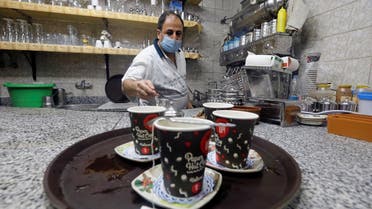 A waiter serves customers in a cafe after months of lockdown, following the outbreak of the coronavirus disease (COVID-19), in Cairo, Egypt, June 27, 2020. (Reuters)