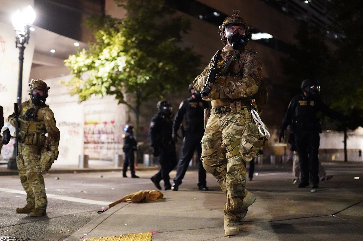 A federal officer watches a crowd of protesters during a standoff between the two groups at the Mark O. Hatfield US Courthouse in Portland, Oregon. (File photo: AFP)