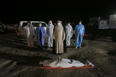 Shiite cleric prays by the body of coronavirus victim at Wadi al-Salam cemetery near Najaf, Iraq, Sunday, July 19, 2020. (AP)