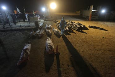 Shiite cleric prays by the grave of coronavirus victim at Wadi al-Salam cemetery near Najaf, Iraq, Sunday, July 19, 2020. A special burial ground near the Wadi al-Salam cemetery has been created specifically for COVID-19 victims since rejections of such burials have continued in Baghdad cemeteries and elsewhere in Iraq. (AP)