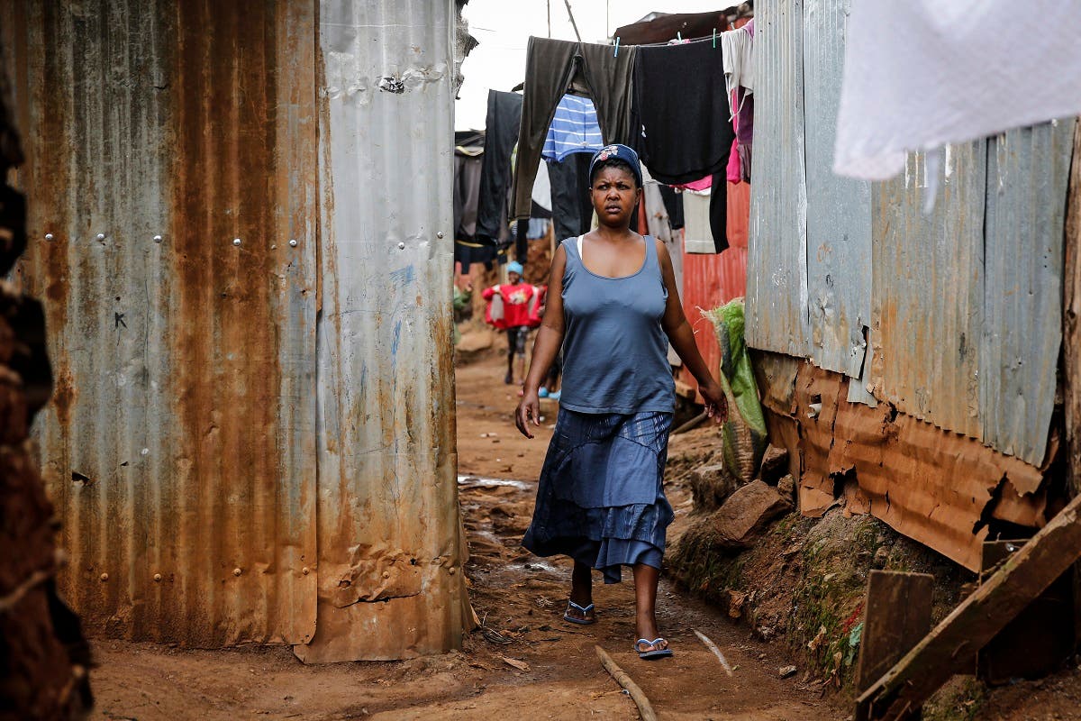 Traditional birth attendant Emily Owino walks down an alley near her home, where she assists women in delivering babies, in the Kibera slum of Nairobi, Kenya Friday, July 3, 2020. (AP)