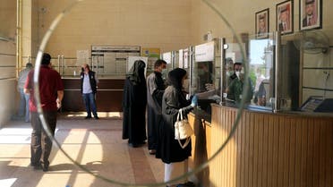 People wearing protective face masks wait to complete their paper work in the Civil Status Department after Jordan's public sector employees returned gradually to work. (File photo: Reuters)