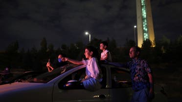 An Iranian family sits in their car while watching a drive-in circus, following the outbreak of the coronavirus disease, in Tehran, Iran, on July 22, 2020. (Reuters)