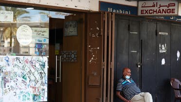 A man sits outside of a currency exchange shop in Beirut, Lebanon June 15, 2020. (Reuters)