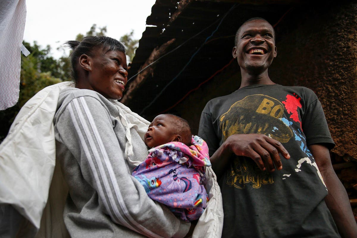 Mother Veronica Atieno, left, holds her daughter Shaniz Joy Juma, center, delivered a month earlier by a traditional birth attendant during a dusk-to-dawn curfew, accompanied by her husband Gabriel Owour Juma, right, in the Kibera slum of Nairobi, Kenya Friday, July 3, 2020. (AP)