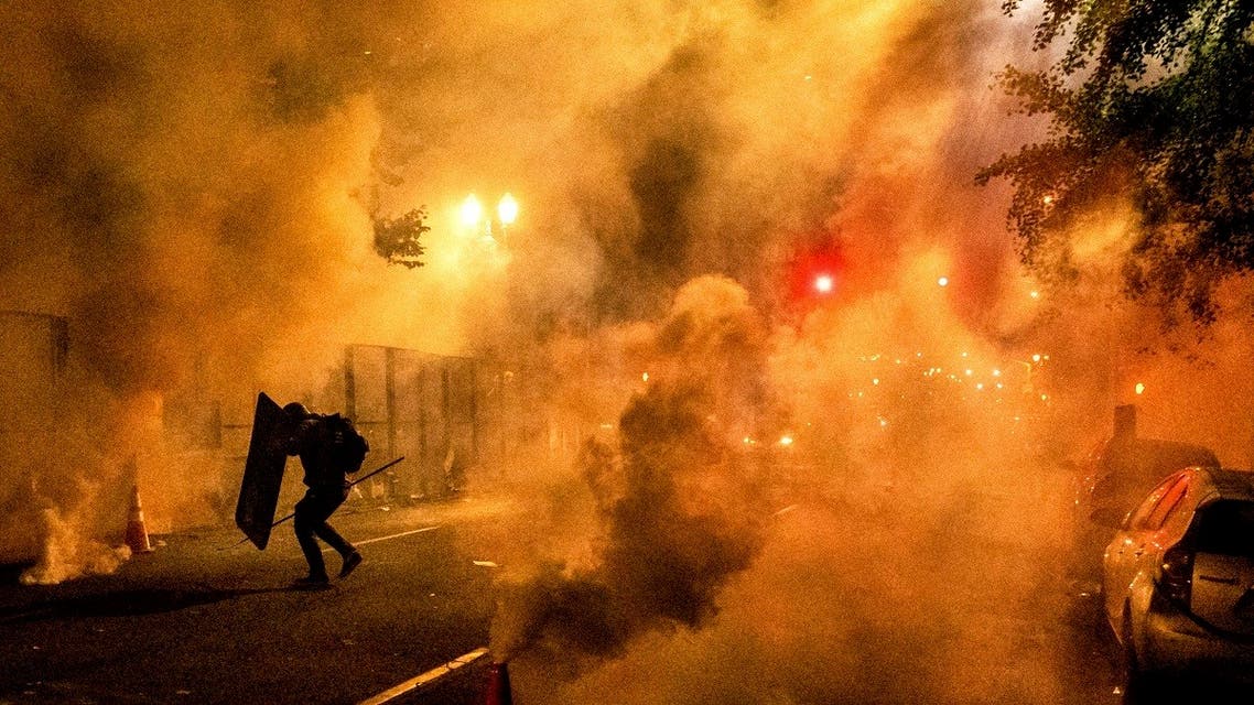 A Black Lives Matter protester uses a shield as federal officers use chemical irritants to disperse demonstrators at the Mark O. Hatfield United States Courthouse on Friday, July 24, 2020, in Portland, Oregon. (AP)