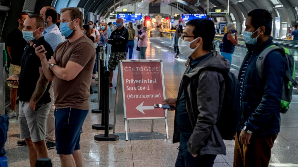 Dozens of passengers from various countries queue at the Centogene test center for a Covid-19 test at the airport in Frankfurt, Germany on July 24, 2020. (AP)