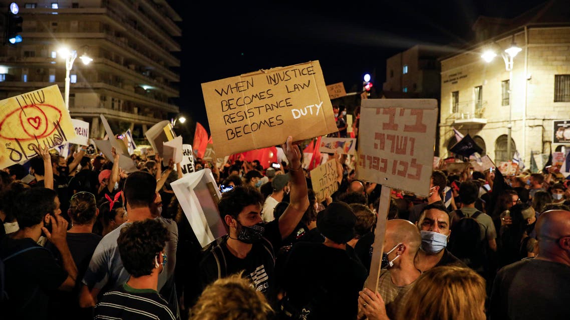 Protesters, clad in masks due to the COVID-19 coronavirus pandemic, gather for a demonstration against the Israeli government near the Prime Minister's residence in Jerusalem. (AFP)