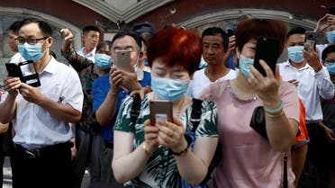People take pictures of a bus, which US Consulate staff loaded up in the morning, as it leaves the US Consulate General in Chengdu, Sichuan province, China, on July 26, 2020. (Reuters)